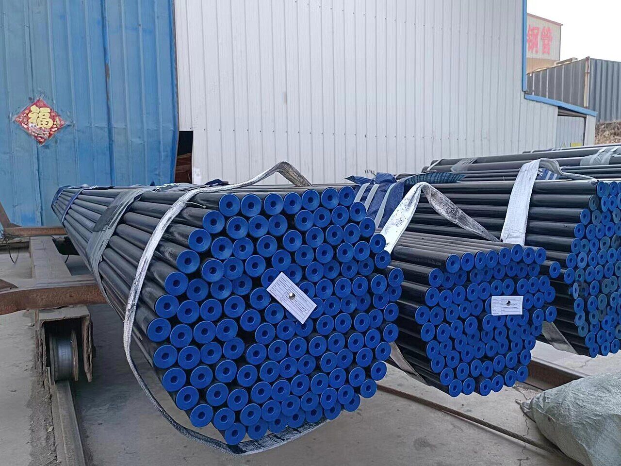 Bundles of seamless steel pipe with capped ends in a mill yard